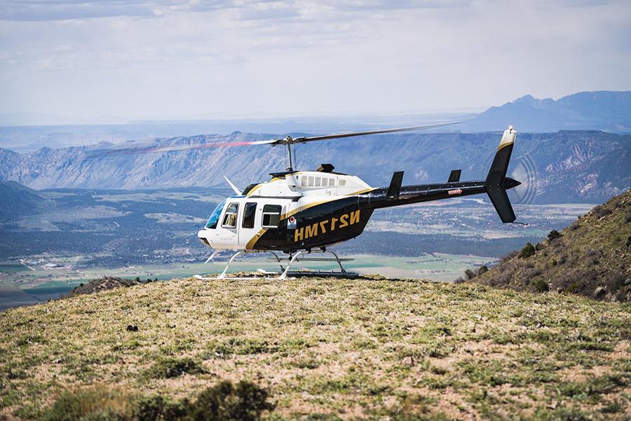 贝尔206直升机在山顶上的照片.
