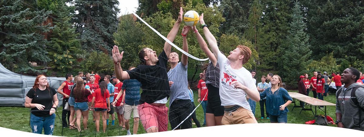 Group of SUU students playing volleyball outside