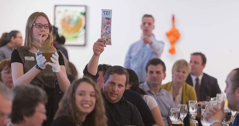 Man holding up number for item at art auction